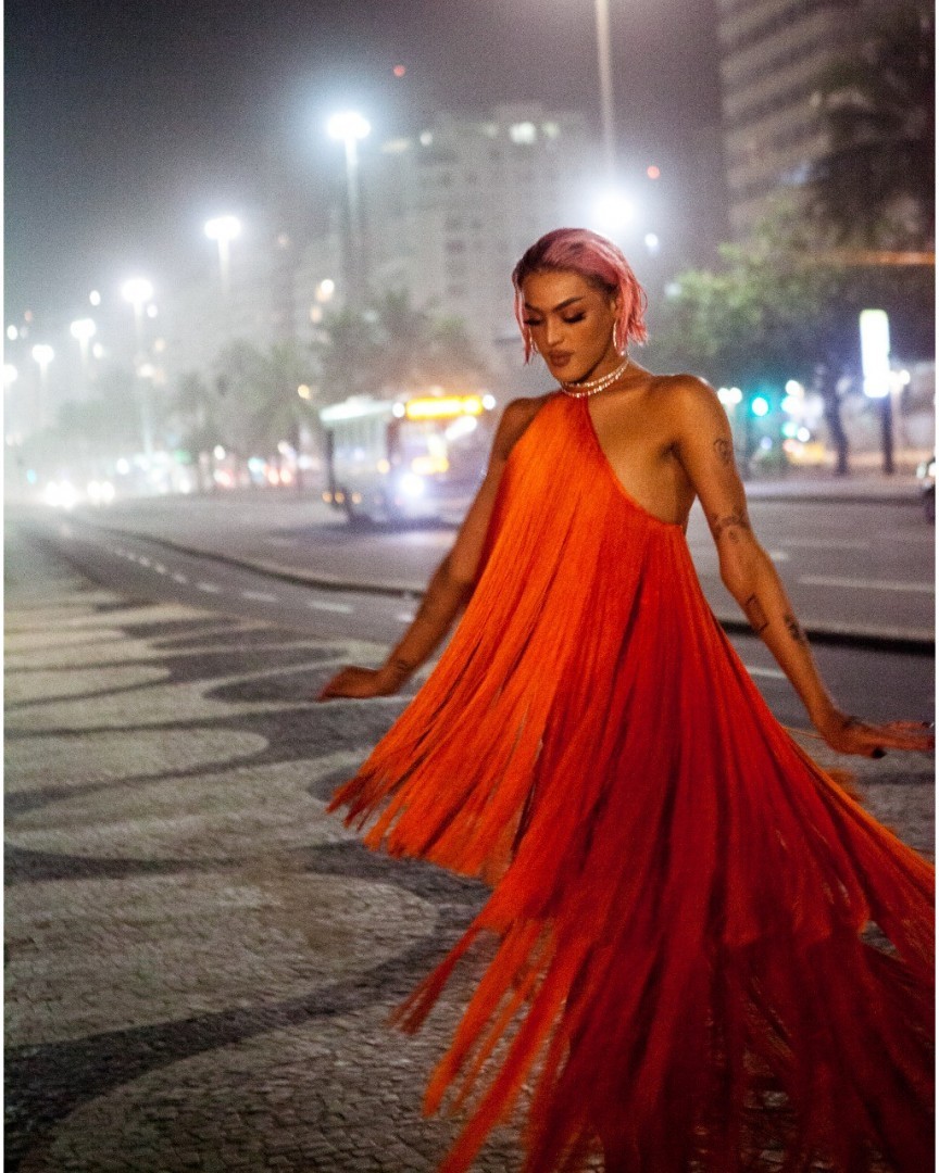 Nas gravações, Pabllo usava um vestido laranja de franjas e os cabelos tingidos de rosa com aspecto molhado. (Foto: Rafael Di Celio/Divulgação) Nas gravações, Pabllo usava um vestido laranja de franjas e os cabelos tingidos de rosa com aspecto molhado. (Foto: Rafael Di Celio/Divulgação)