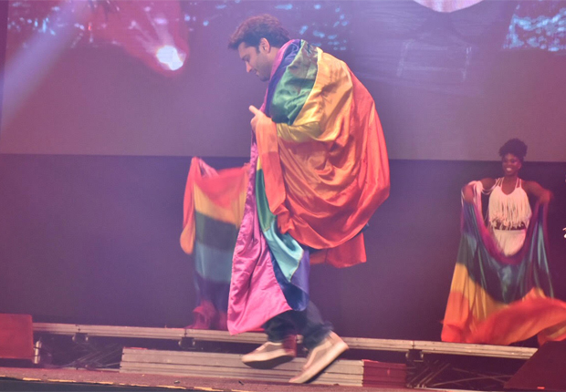 Armando Babaioff se enrolou em uma bandeira com as cores do arco-íris para curtir o show de Daniela Mercury. (Foto: Reprodução/Instagram)